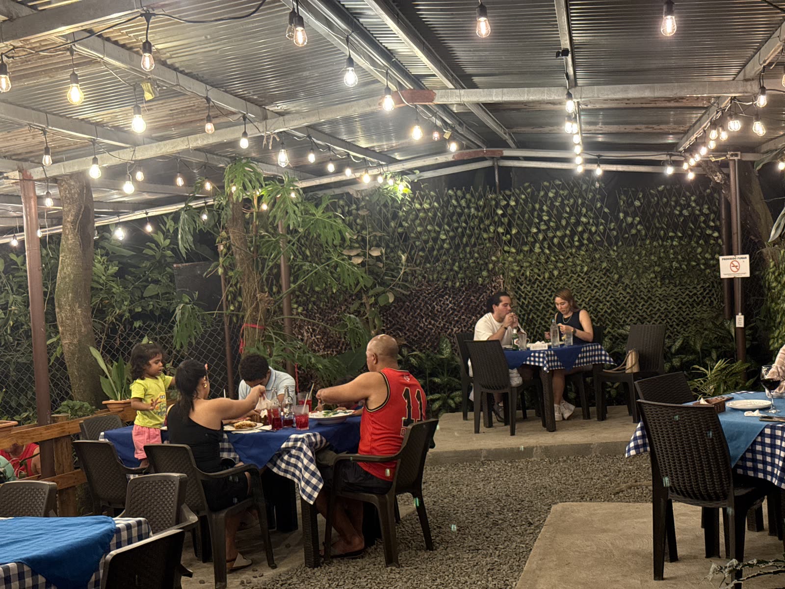 Jardín real de La Divina Commedia El Valle de noche, con familias cenando